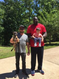 2 clients holding a baby and a Presa Canario puppy