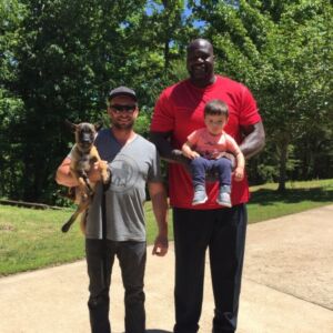 2 clients holding a baby and a Presa Canario puppy
