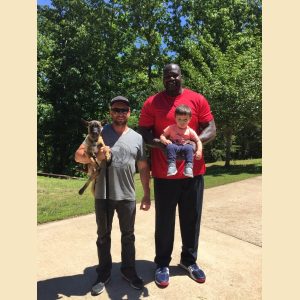 2 clients holding a baby and a Presa Canario puppy