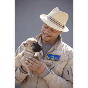Sanders Kennels client smiling while holding a beige Presa Canario puppy