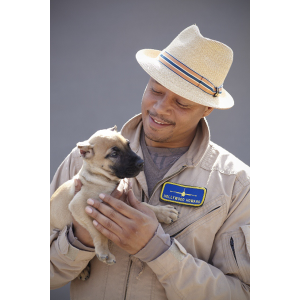 Sanders Kennels client smiling while holding a beige Presa Canario puppy